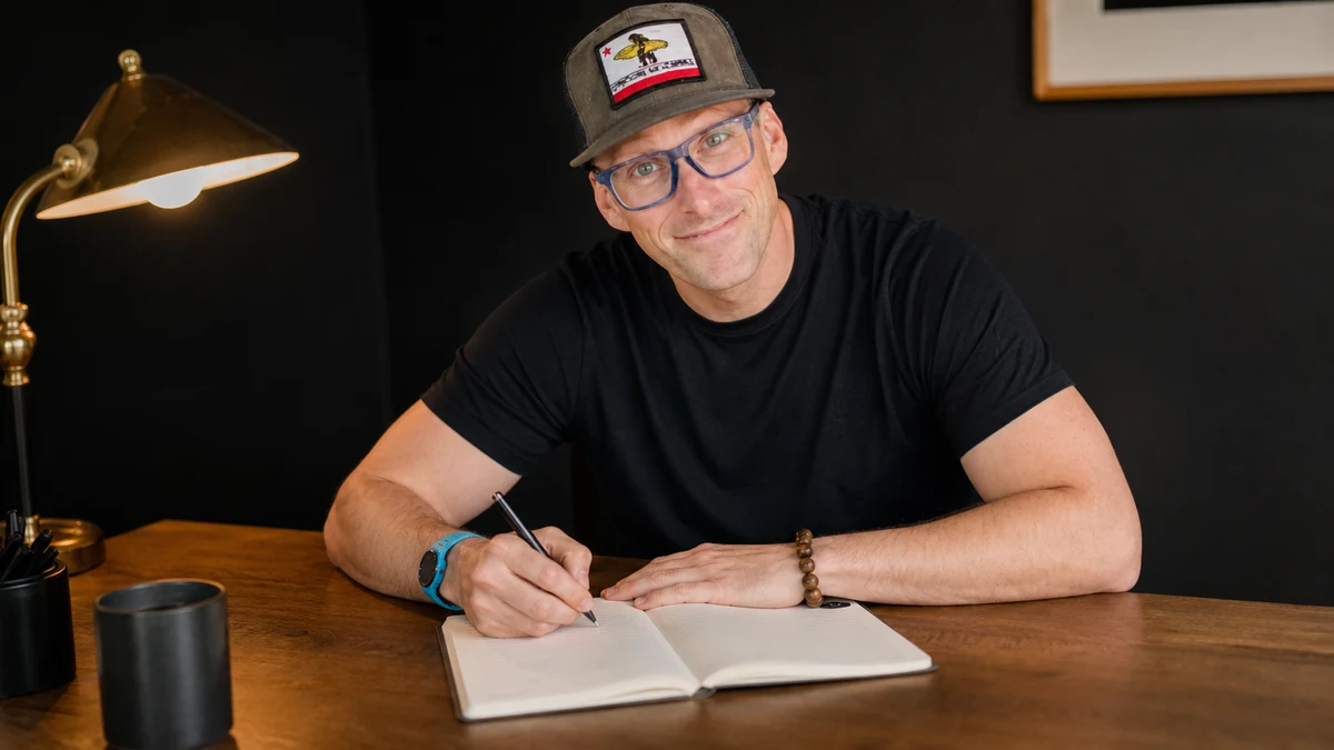 Steve at his desk, writing in a notebook.