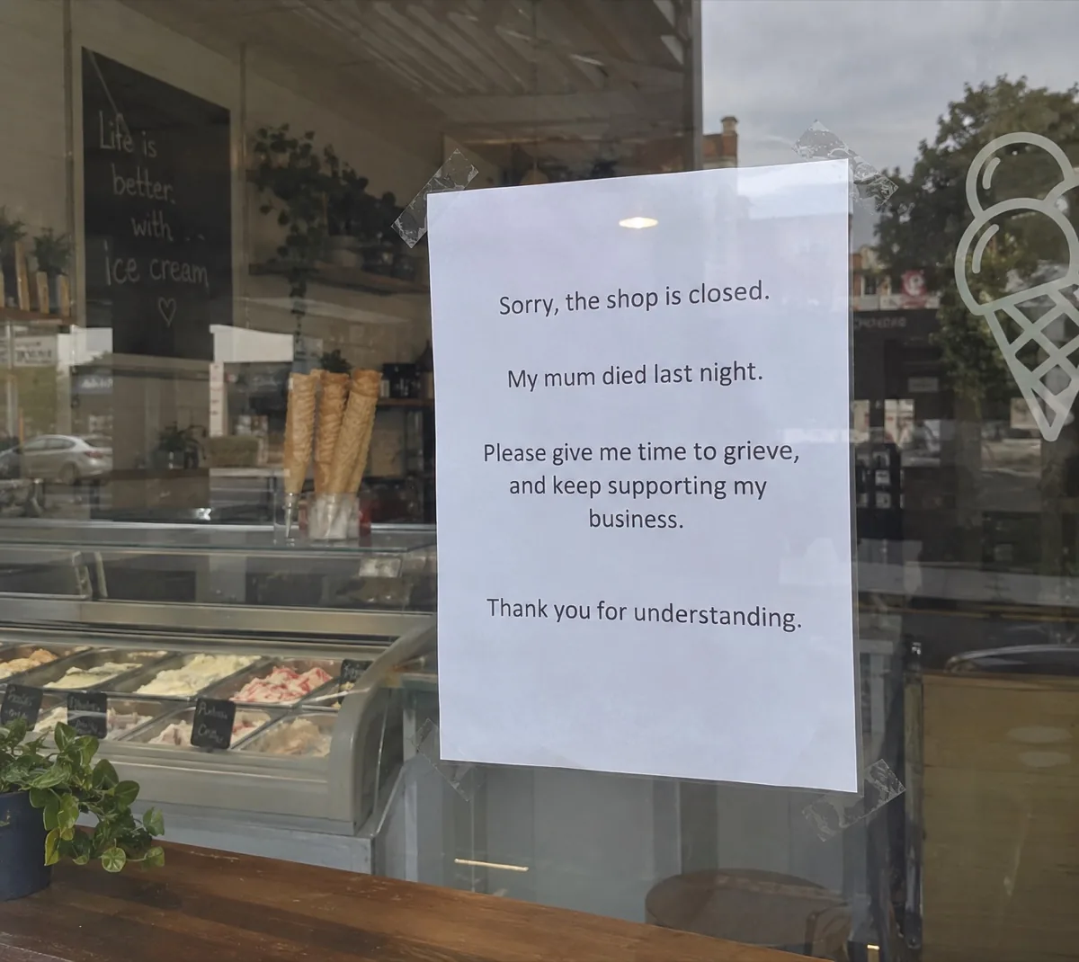 A sign taped to the ice cream shop window: Sorry, the shop is closed. My mum died last night. Please give me time to grieve, and keep supporting my business.